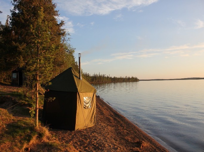 Lakeside sauna tent at golden hour