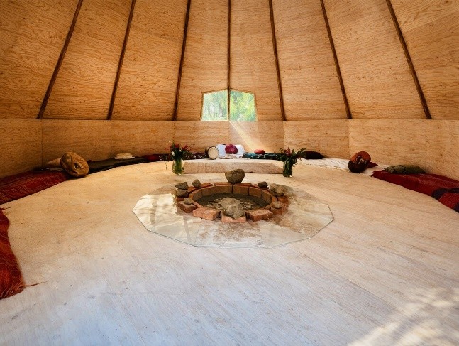 Wooden tipi interior with central firepit